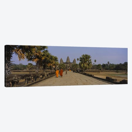 Two monks walking in front of an old temple, Angkor Wat, Siem Reap, Cambodia Canvas Print #PIM5884} by Panoramic Images Canvas Print
