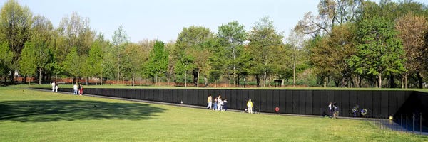 Tourists standing in front of a Monument Vietnam Veterans Memorial, Washington DC, USA