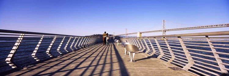 Couple walking on a pier, Bay Bridge, San Francisco, California, USA