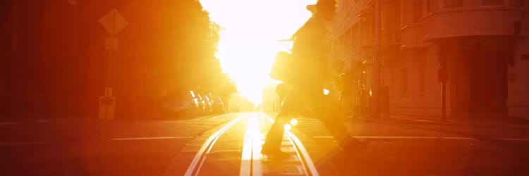 Side profile of a person crossing the cable car tracks at sunset, San Francisco, California, USA