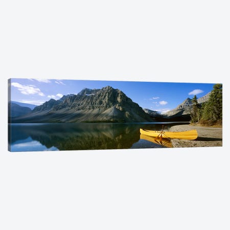 Crowfoot Mountain With A Lone Canoe On The Shore Of Bow Lake, Banff National Park, Alberta, Canada Canvas Print #PIM6618} by Panoramic Images Canvas Art Print