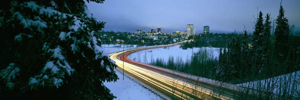 Alaska: Autumobile lights on busy street, distant city lights, frozen Westchester Lagoon, Anchorage, Alaska, USA. by Panoramic Images
