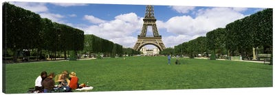 Tourists sitting in a park with a tower in the background, Eiffel Tower, Paris, Ile-de-France, France Canvas Art Print - Group Art