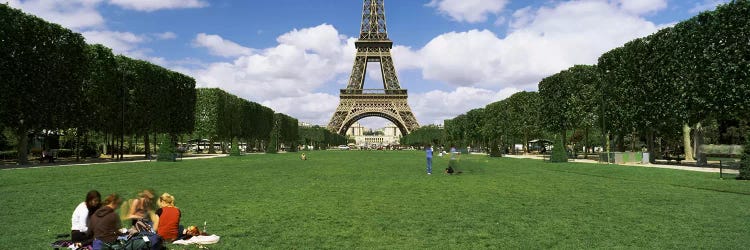 Tourists sitting in a park with a tower in the background, Eiffel Tower, Paris, Ile-de-France, France