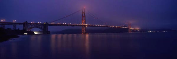 Golden Gate Bridge: Suspension bridge lit up at dawn viewed from fishing pier, Golden Gate Bridge, San Francisco Bay, San Francisco, California, USA by Panoramic Images