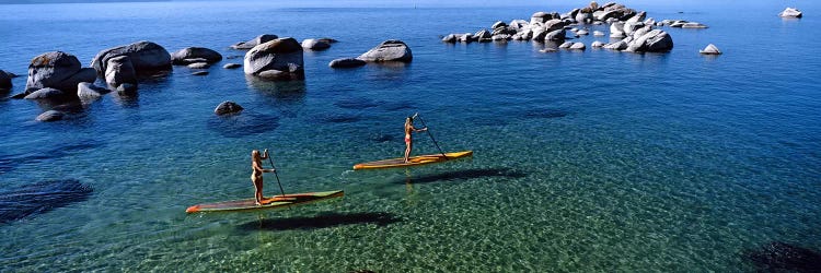 Two women paddle boarding in a lake, Lake Tahoe, California, USA