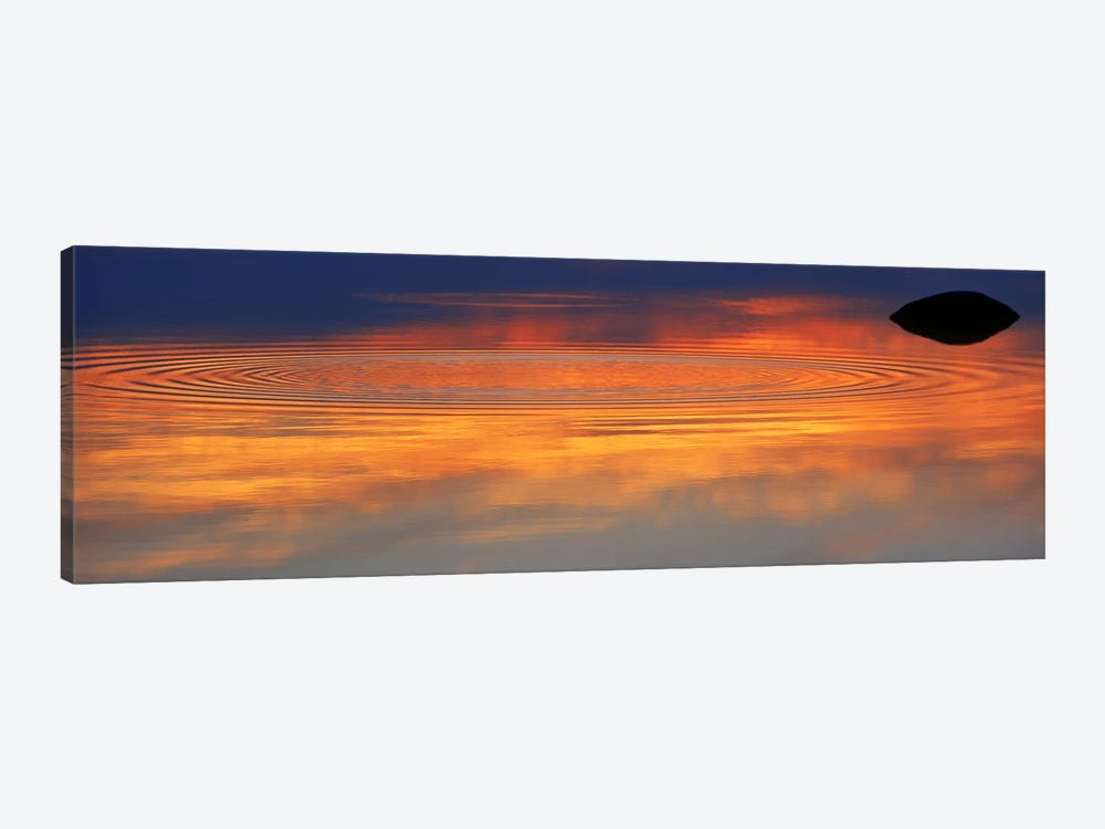 Reflection of clouds with circular ripples spreading outward across glassy lake waters at sunset by Panoramic Images 1-piece Canvas Wall Art