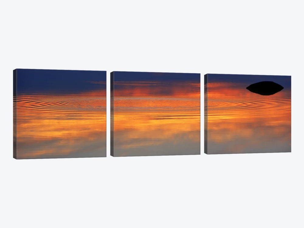 Reflection of clouds with circular ripples spreading outward across glassy lake waters at sunset by Panoramic Images 3-piece Canvas Wall Art