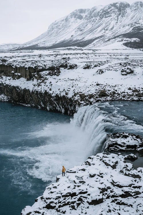 Small Person Standing In Front Of An Icelandic Waterfall