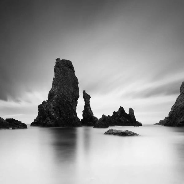 Sebastien Del Grosso: Dark rocks in a blue ocean under cloudy sky in a bad weather #7 by Sebastien Del Grosso