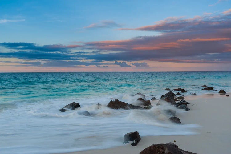 Long Exposure Of Surf Surging Onto A Rocky Beach At Sunset. Anse Bambous Beach, Fregate Island, Seychelles.