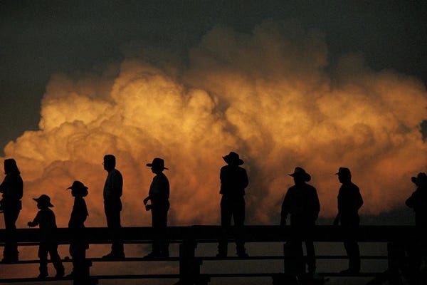 Home On The Range: Nebraskans Look Out Over An Approaching Storm At Burwell's Big Rodeo by Joel Sartore