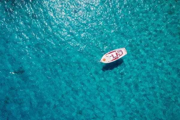 Greece: Boat In The Blue Mediterranean Sea by Matteo Colombo