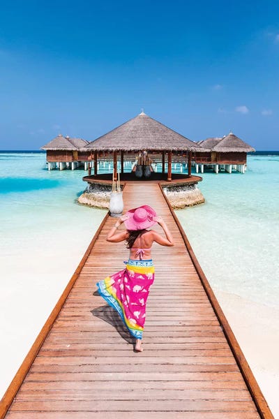 Islands: Woman With Sarong Walking On Jetty, Maldives by Matteo Colombo