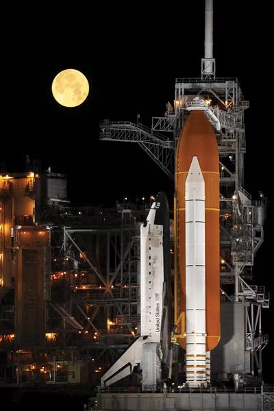 Science: A Nearly Full Moon Sets As Space Shuttle Discovery Sits Atop The Launch Pad by Stocktrek Images