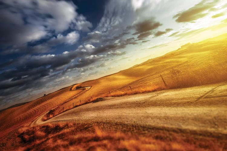 A Country Road In Field At Sunset Against Moody Sky, Tuscany, Italy.