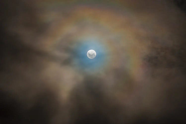 Full Moon And Lunar Corona Amongst Fast-Moving Low Clouds.
