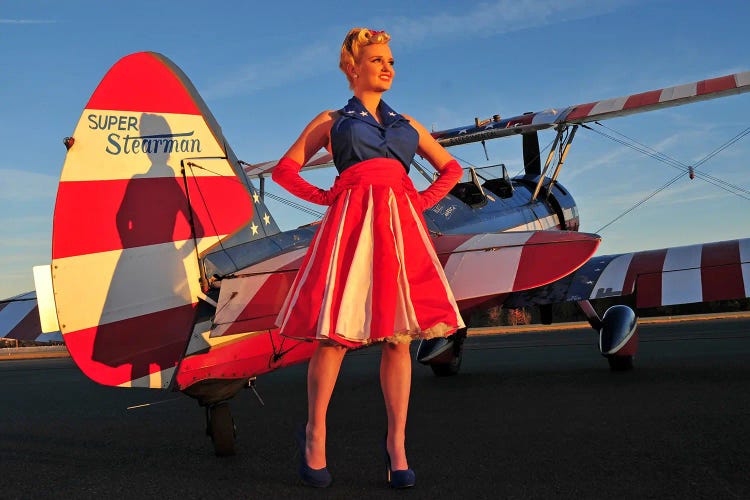 Patriotic Retro Pin-Up Girl Standing With A Matching Stearman Biplane