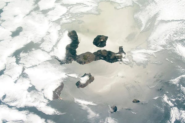 View From Space Of Several Of The Galapagos Islands Between Cloud Cover And Sunglint