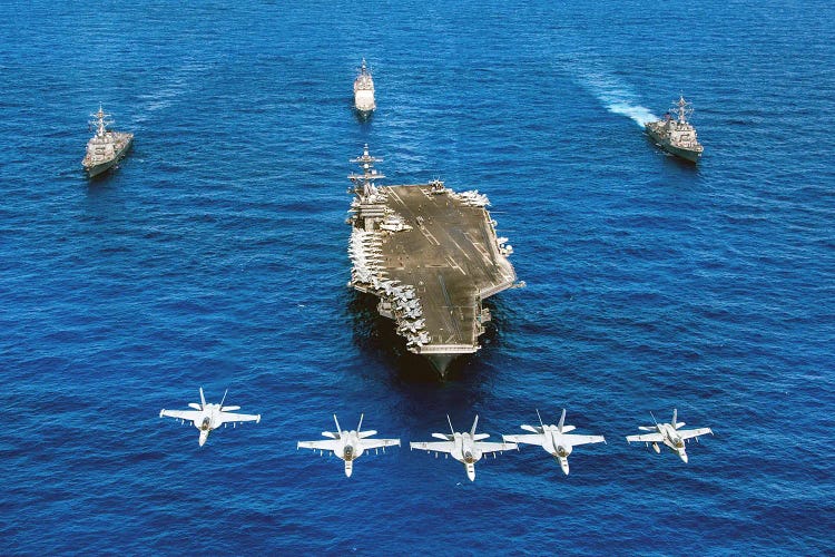 F/A-18 Hornets Fly Over A Formation Of US Navy Ships Transiting The Pacific Ocean