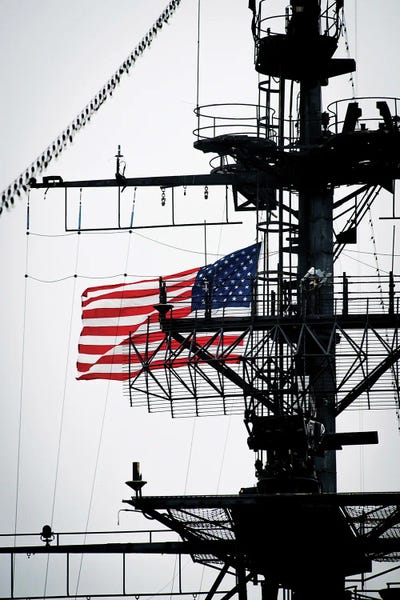 Warships: The National Ensign Waves From The Mast Aboard The USS Midway Museum by Stocktrek Images