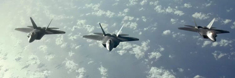 A Three-Ship Formation Of F-22 Raptors Fly Over The Pacific Ocean by Stocktrek Images wall art