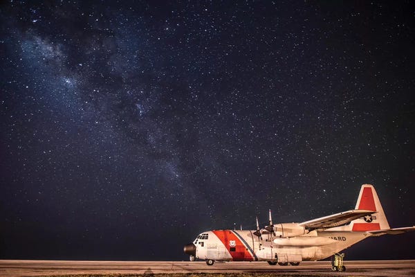 Coast Guard: A US Coast Guard C-130 Hercules Parked On The Tarmac On A Starry Night by Stocktrek Images