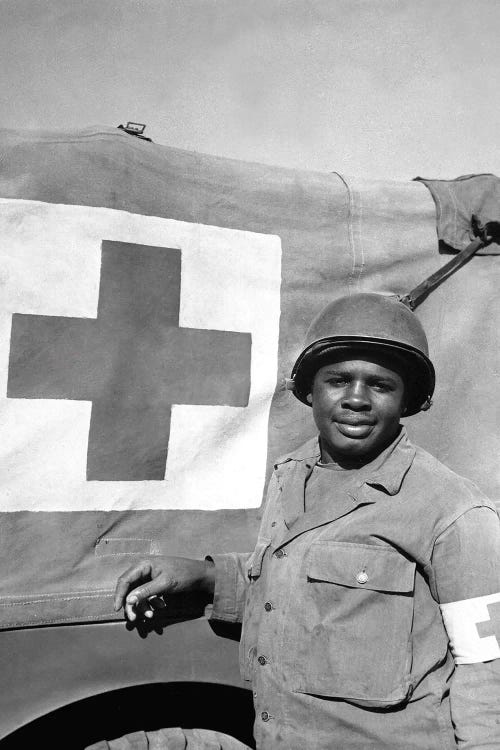 A WWII Soldier Stands Next To His Red Cross Vehicle