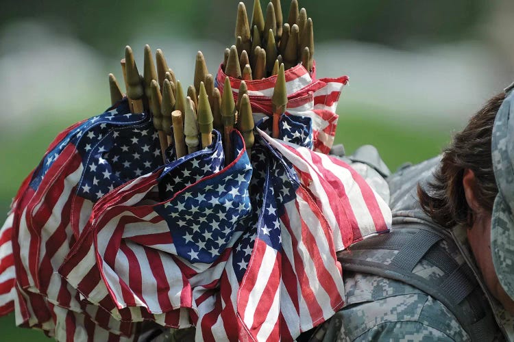 An Army Soldier's Backpack Overflows With Small American Flags