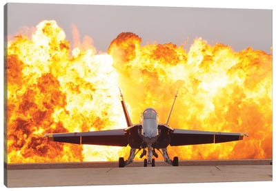 An F/A-18 Hornet Sits On The Flight Line As A Wall Of Fire Detonates Behind It Canvas Art Print
