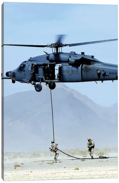 Pararescuemen Descend From An HH-60 Pave Hawk Helicopter Canvas Art Print