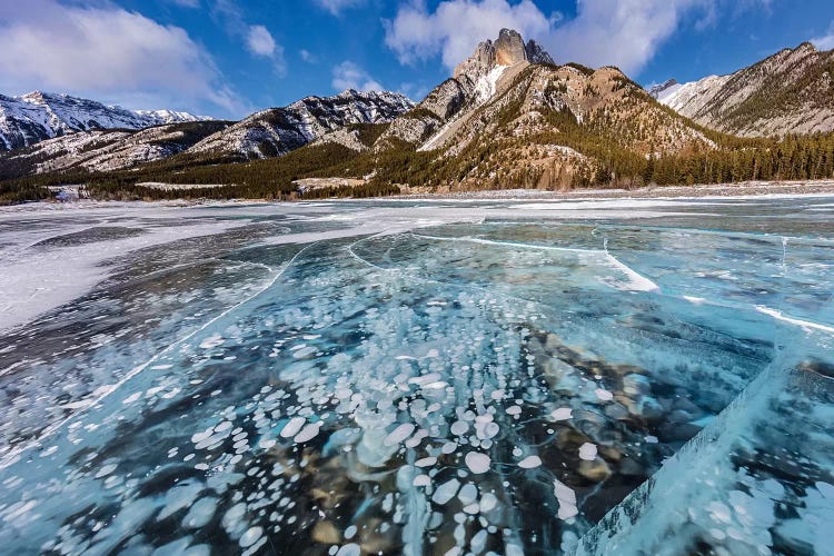 Mt. Abraham at sunrise and methane ice bubbles under clear ice on Abraham Lake, Alberta, Canada