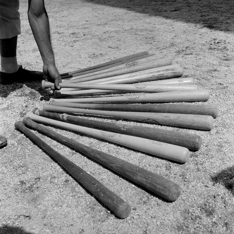 1950s Baseball Player Selecting From A Variety Of Bats