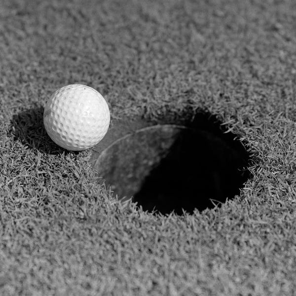 Golf: 1950s Close-Up Of Golf Ball On Green On Very Edge Of Cup by Vintage Images