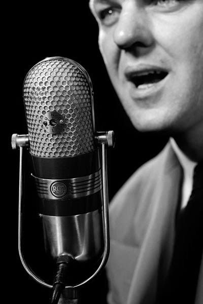 Microphones: 1950s Close-Up Of Man Announcer Talking Into Microphone Newscaster Indoor Symbolic Freedom Of Speech by Vintage Images