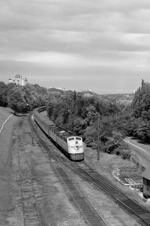 1950s Overhead View Of Streamlined Front Cab Diesel Locomotive Passenger Railroad Train Passing Through Suburban Area