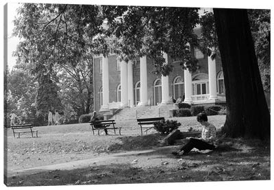 1960s Anonymous Silhouetted Female College Student Sitting Under Tree Studying With Campus Building In Background Canvas Art Print - Vintage Images