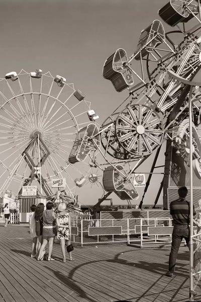 Amusement Parks: 1960s Group Of Teens Looking At Amusement Rides On Pier by Vintage Images