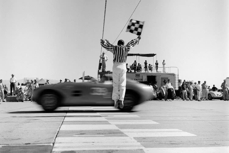 1960s Man Jumping Waving Checkered Flag For Winning Sports Car Crossing The Finish Line