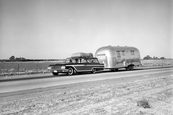 Camping: 1960s-1970s Family Station Wagon And Camping Trailer Driving On Country Highway On Vacation by Vintage Images