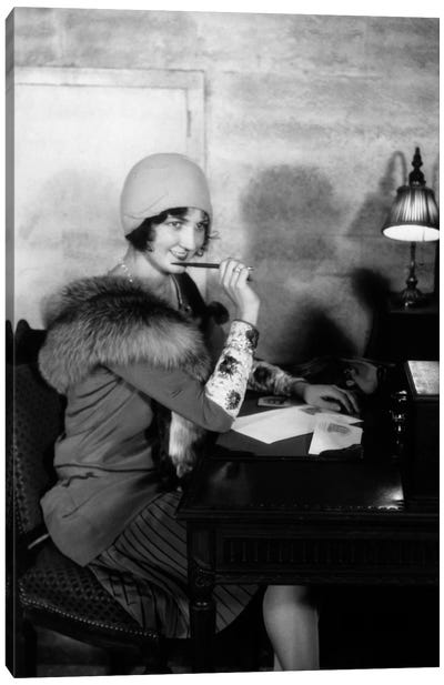 1920s Smiling Woman With Pen To Lips Wearing Cloche Hat And Fur Collar Coat Writing A Letter At Hotel Lobby Desk With Lamp Canvas Art Print - Figurative Photography