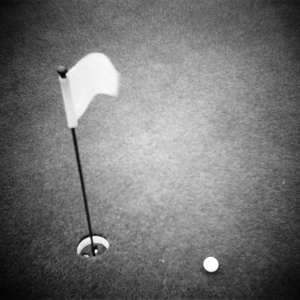 Golf: 2000s Golf Ball On Putting Green With Flag Marker In Hole From Above by Vintage Images