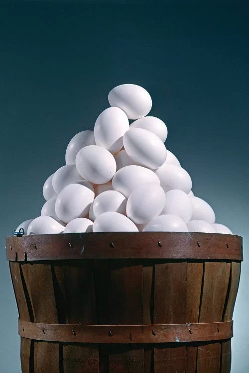 Brown Wooden Bushel Basket Full Of White Chicken Eggs In 1 Basket Pyramid Shape Triangle