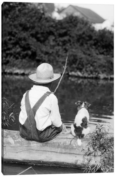 1920s-1930s Farm Boy Wearing Straw Hat And Overalls Sitting On Log With Spotted Dog Fishing In Pond Canvas Art Print - Fishing Art
