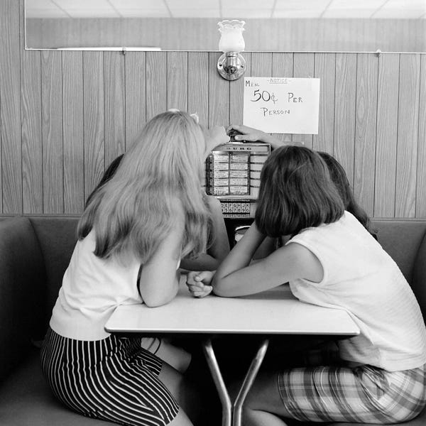 Fashion Photography: 1960s Four Teenage Girls Putting Coins In Slot Of Small Individual Juke Box Of Diner Soda Shop by Vintage Images