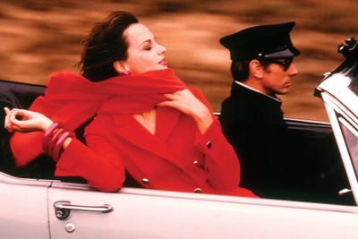 1970s Stylish Woman Red Dress Scarf Driving Open Air Convertible Sports Car Chauffeur Style Fashion Wealth Luxury by Vintage Images metal wall art