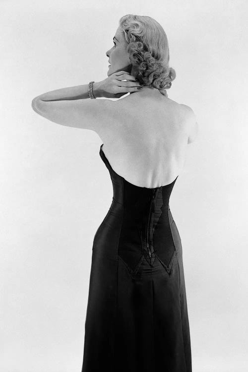 1950S Blonde Woman Wearing Black Strapless Gown Hands And Arms Reaching To Her Neck