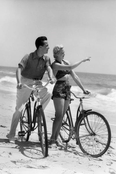 Bicycles: 1930s Couple Man Woman Biking On Beach Woman Pointing To Horizon by Vintage Images