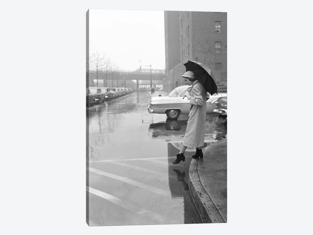 1950s Woman In Rain Coat Hat Boots Holding Umbrella Crossing City Street In Wet Foul Weather by Vintage Images 1-piece Canvas Art Print