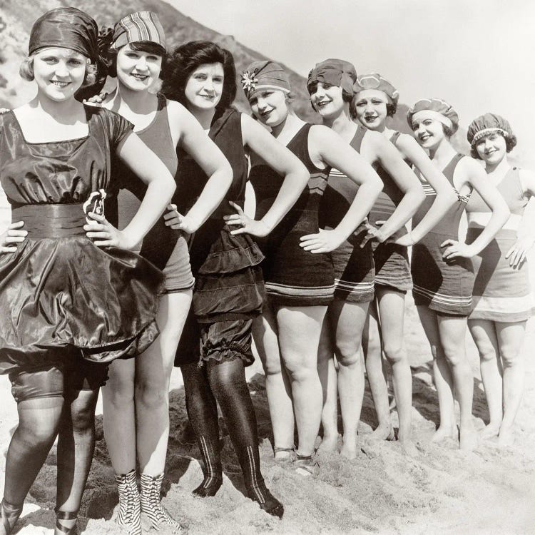 1920s Group Of Smiling Women Wearing One Piece Bathing Suits And Caps Posing Lined Up On Beach Looking At Camera